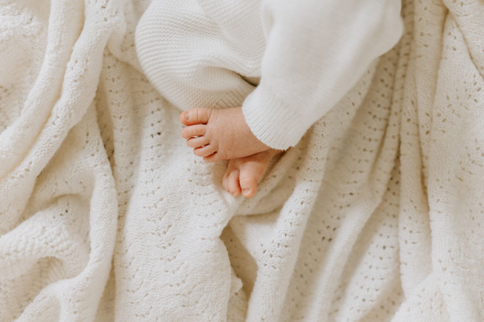 A close up photo of a baby's toes on a white knit blanket by Lafayette, Indiana newborn photographer Vanessa Stoller.