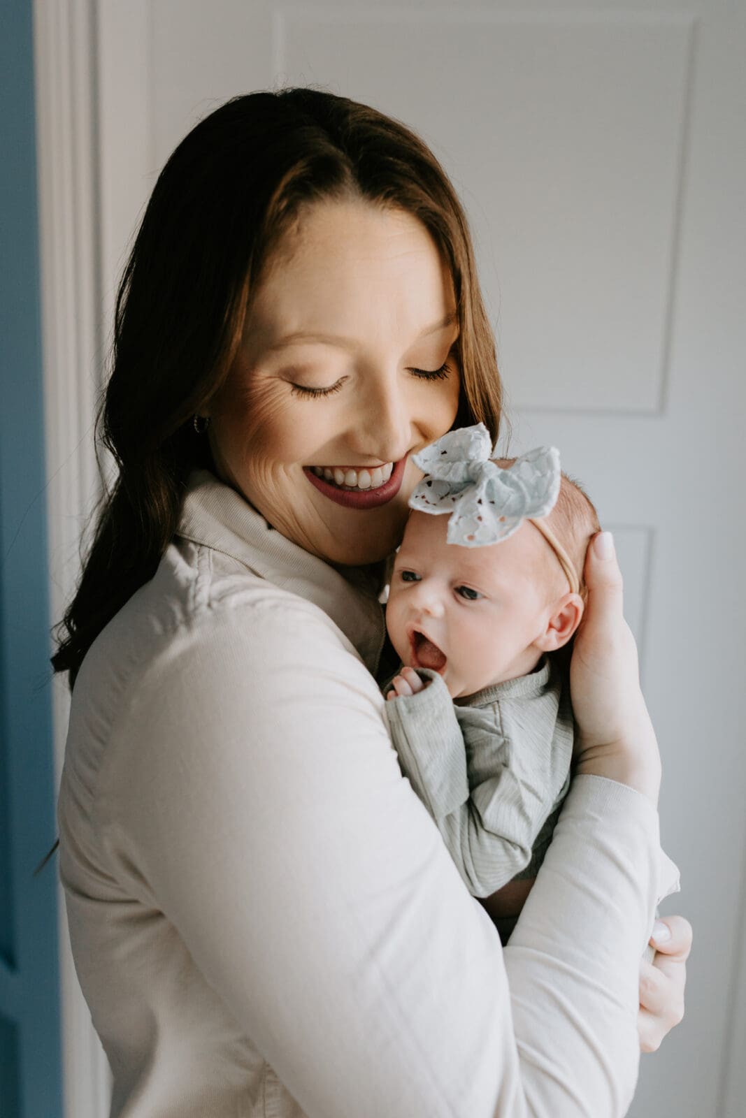 A mom holds her newborn baby close during a photo session in West Lafayette with Vanessa Stoller Photography.