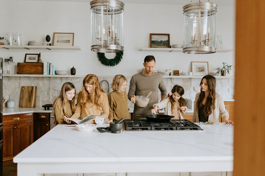 family makes pancakes in kitchen