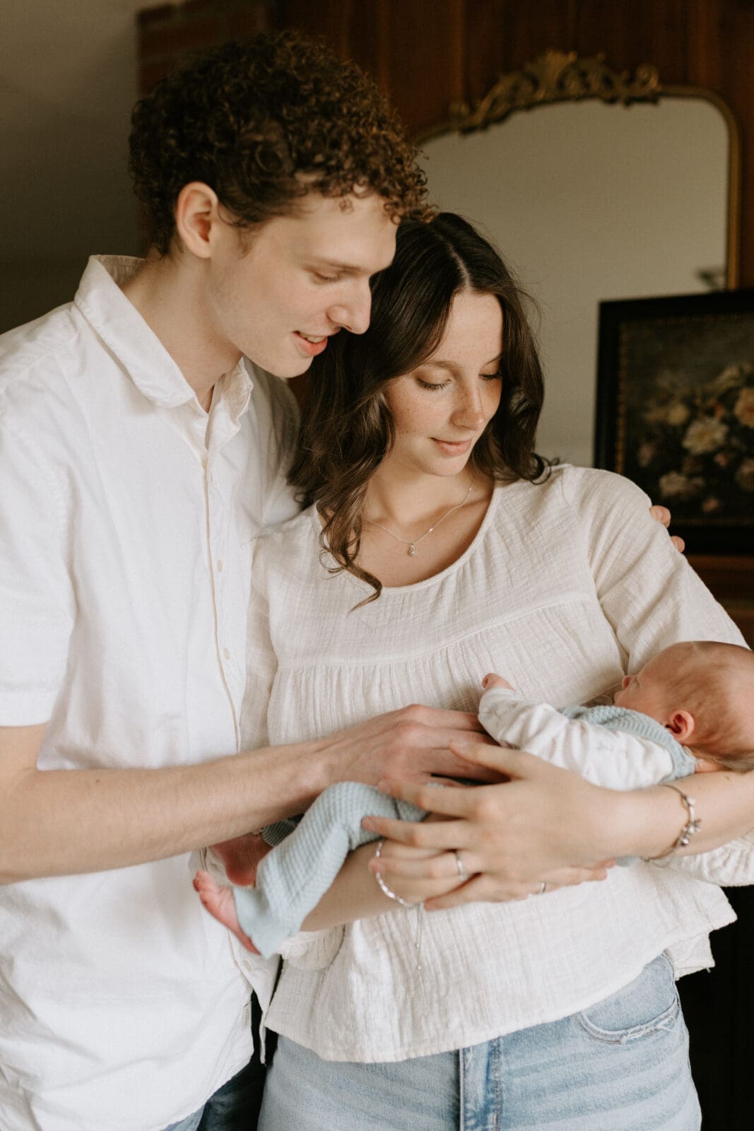 Parents look at their newborn baby for a portrait with Vanessa Stoller Photography.
