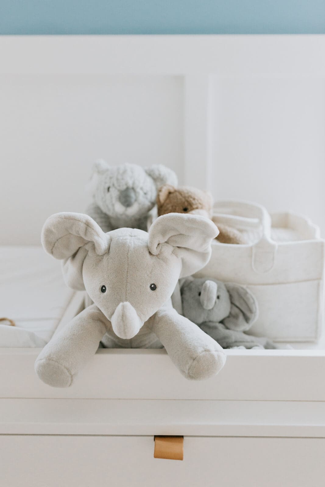A photo of a stuffed elephant and other stuffed animals on a changing table in a beautifully decorated Lafayette, Indiana nursery.