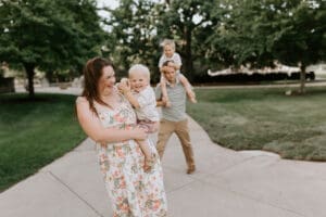 a mom and dad laugh while carrying their small children at purdue university